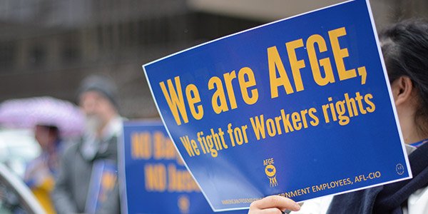 Rally goer holds sign that says We are AFGE, We fight for Workers rights