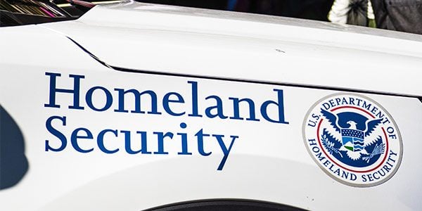 Side of government vehicle with the lettering Homeland Security with the Department of Homeland Security seal.