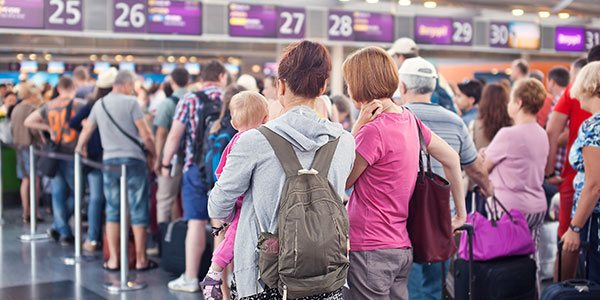 Woman with a baby waiting at airport check in line