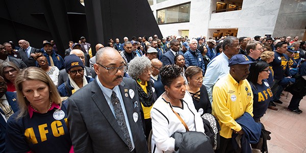 Union leaders stand in silent protest at the Hart Senate Building. In the foreground is Liz Shuler, Everett Kelley, Cheryl Eliano, and David Mollett. Other demonstrators are in the background.