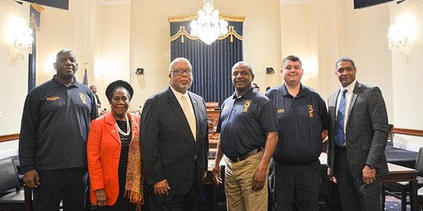 TSA council members pose for photo with lawmakers in side a House hearing room. 