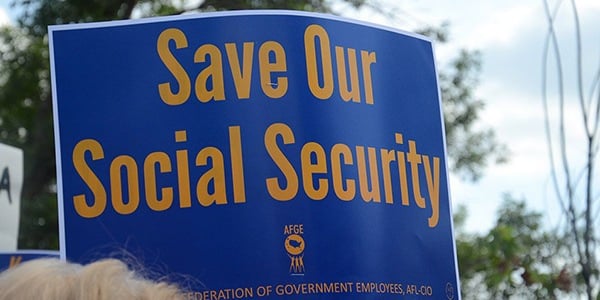 Rally sign with blue background and yellow text that reads Save Our Social Security