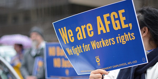 Image of rally goer holding sign that says We are AFGE, We fight for Workers rights