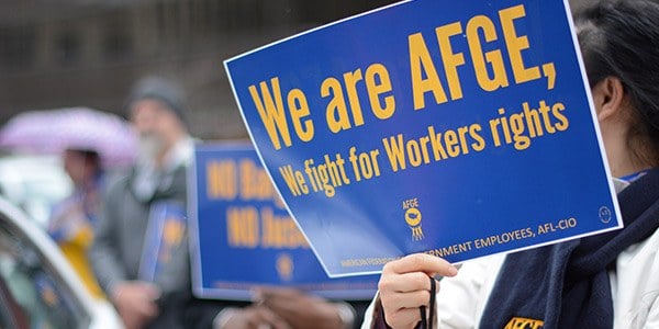 Rally goer holding sign that reads We are AFGE, We fight for workers rights