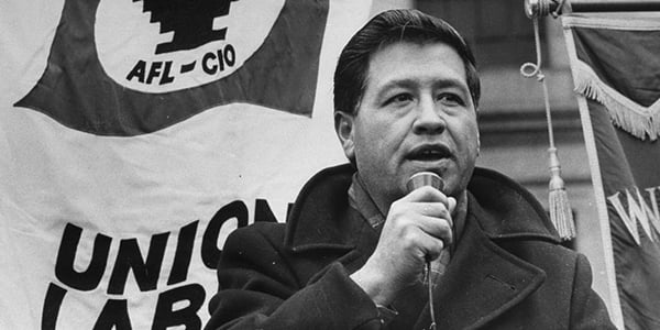 Photo of Cesar Chavez in front of an AFL-CIO banner with a microphone in his hand