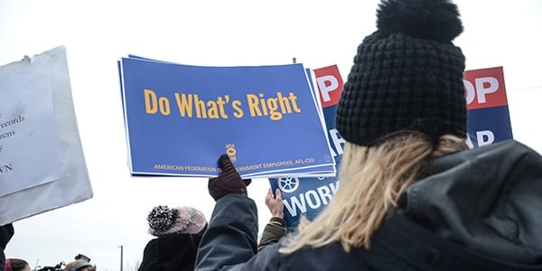 Rally goer at US Capitol holding sign that says Do What's Right