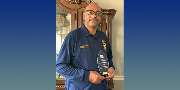 Everett Kelley holding award