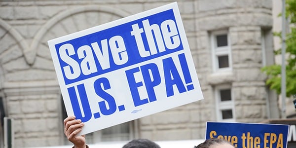 White rally sign with blue text that reads Save the US EPA.