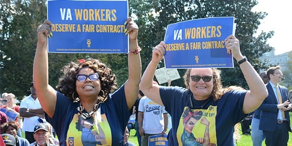 Two women holding rally signs that read VA workers deserve a fair contract