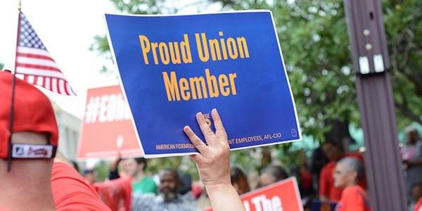 Rally goer holding sign that reads proud union member