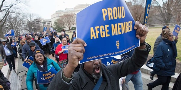 Rally goer holding sign that says Proud AFGE Member