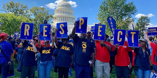 Rally goers holding up signs out side to the US Capitol that spell R-E-S-P-E-C-T