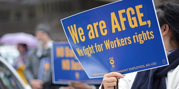 Rally-goer holding sign that says We are AFGE, We fight for workers' rights