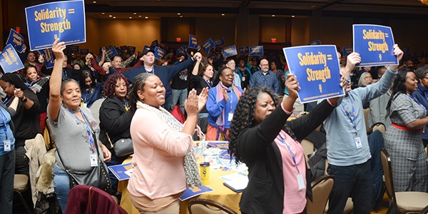 AFGE members standing at Legislative Conference holding signs that read Solidarity = Strength