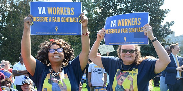 Two women at a rally holding signs that read VA Workers Deserve a Fair Contract