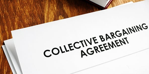 Collective bargaining agreement and note pad with glasses.