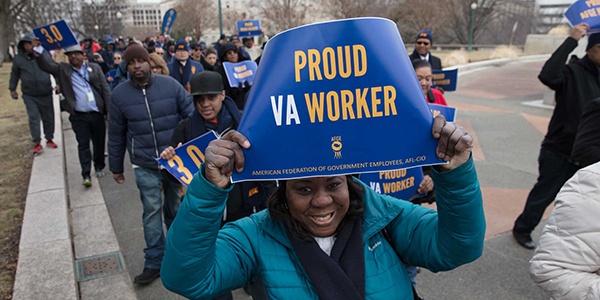 Rally goer holding that reads Proud VA Worker