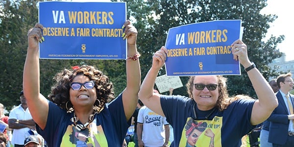 Two AFGE activists holding signs