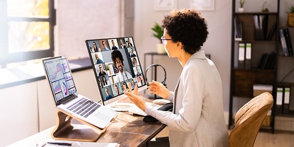 Person sitting at two computers during a webinar