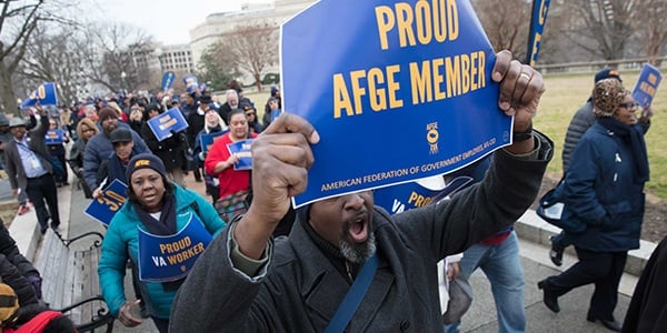 Rally-goer holding sign that says Proud AFGE Member