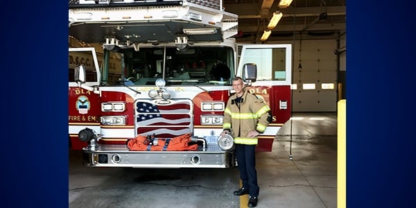 Gus Maschman in front of a fire truck.