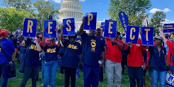 Activists holding up signs that spell RESPECT