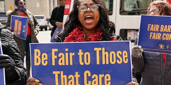 Rally goer holds sign that reads be fair to those that care