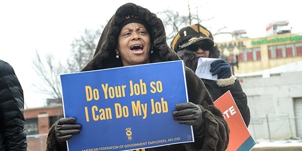 Rally-goer holds sign that reads Do your job so I can do my job.