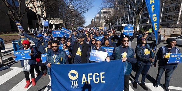 Large group of AFGE members holding a banner, heading to a rally