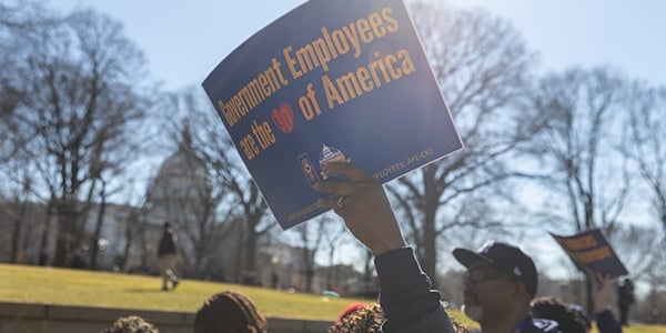 AFGE member holding a sign that says Government Employees are the Heart of America