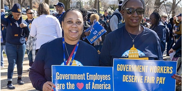 Two AFGE activists holding signs