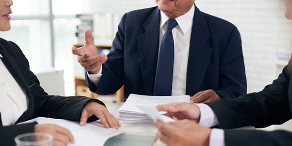 Stock photo of people talking around a conference table