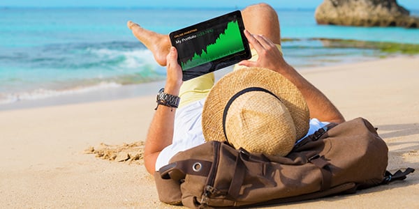 Stock image of someone laying on the beach with a tablet