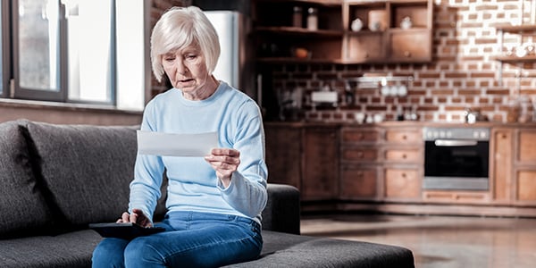 Older woman looking at bill and calculator