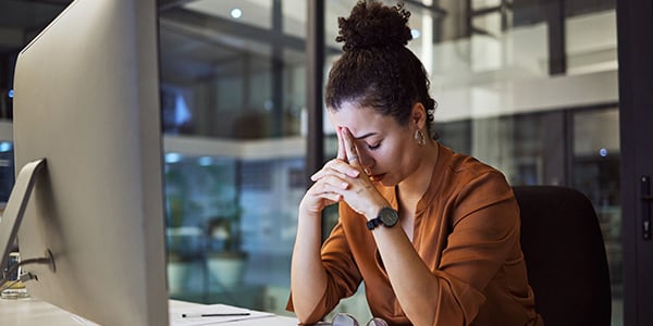 Woman sitting in front of a computer looking stressed