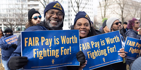 Two AFGE activists holding rally signs